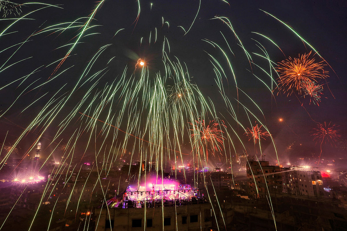 Fireworks and laser lights illuminate sky of the old part of Dhaka city as revellers celebrate Shakrain festival on 14 January 2019. Photo: Dipu Malakar