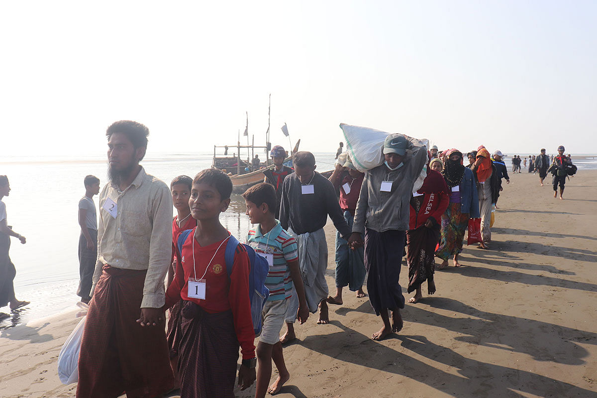 Rohingya people who were arrested at sea in December walk on a beach after being transported by Myanmar authorities to Thalchaung near Sittwe in Rakhine state on 13 January 2020. Photo: AFP