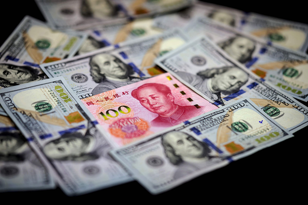 This photo illustration shows a Chinese 100 yuan note (C) and US 100 notes in Beijing on 14 January 2020. The United States removed the currency manipulator label it imposed on China last summer, a sign of easing tensions between the economic powers after nearly two years of conflict. Separately, official data showed that China’s trade surplus with the United States narrowed in 2019, a day before the two countries sign a “phase one” trade deal in Washington. Photo: AFP