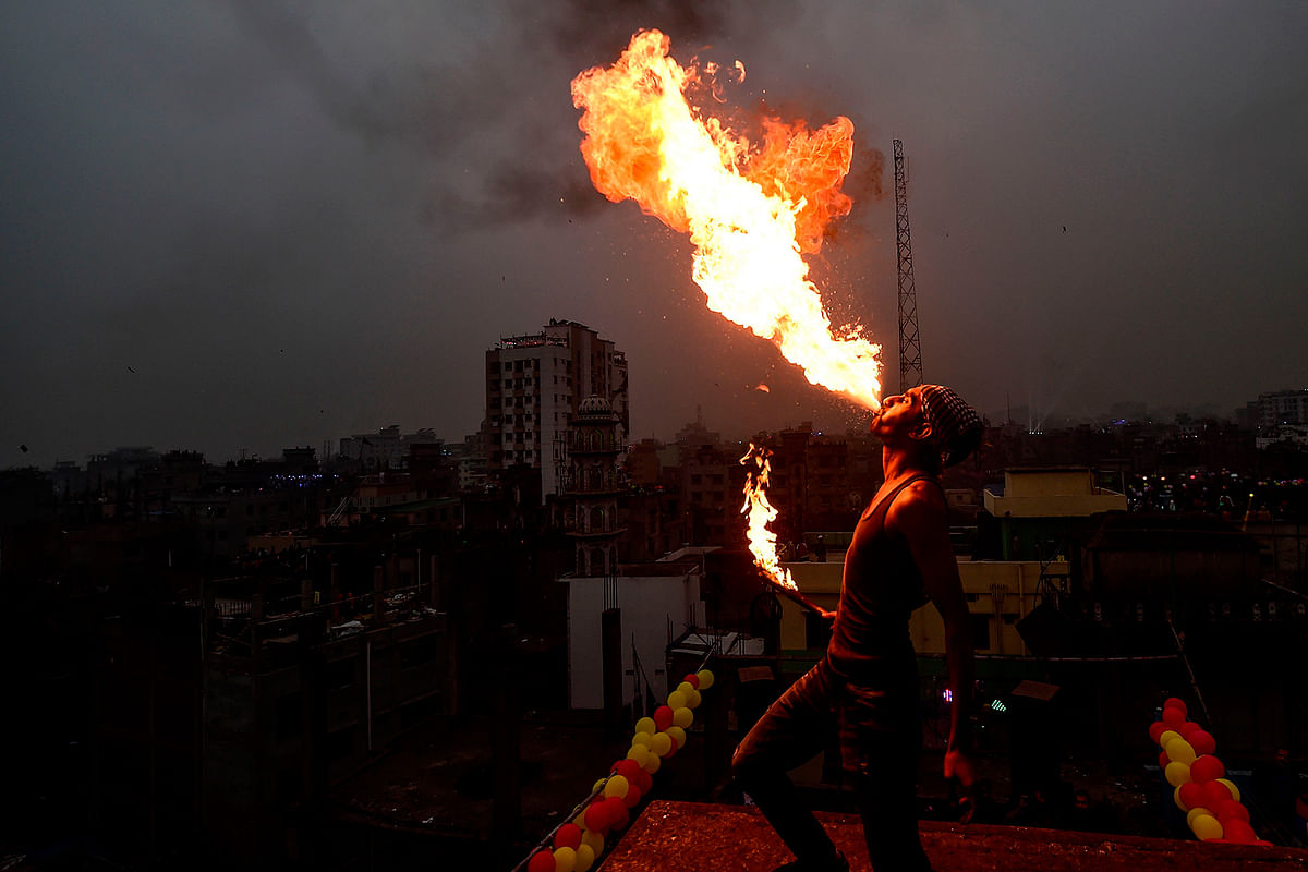 A youth performs fire-eating during the Shakrain festival or the Kite festival in Dhaka on 14 January 2020. Photo: AFP