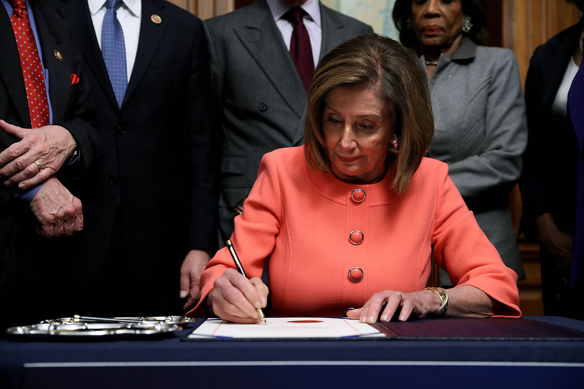 US Speaker of the House Nancy Pelosi (D-CA) signs the articles of impeachment against president Donald Trump during an engrossment ceremony in the Rayburn Room at the US Capitol on 15 January 2020 in Washington, DC. Photo: AFP