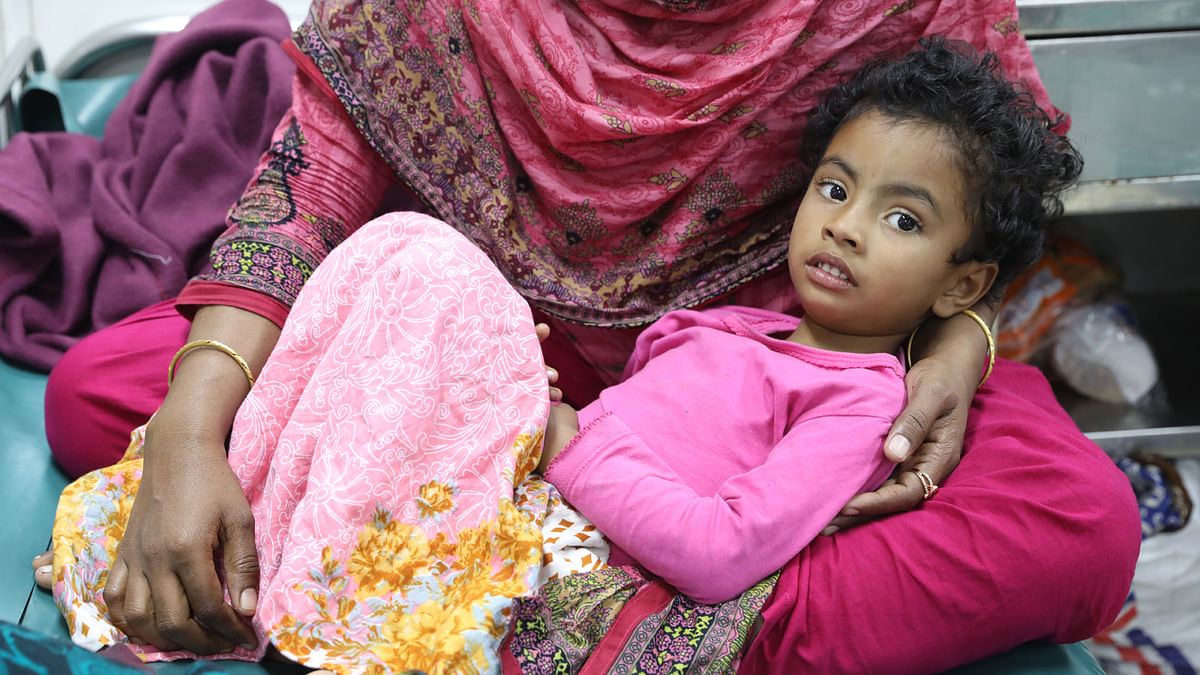 A woman holds a child in her lap as she suffers from cold-related disease at icddr,b at Mahakhali, Dhaka on 15 January 2020. Photo: Abdus Salam