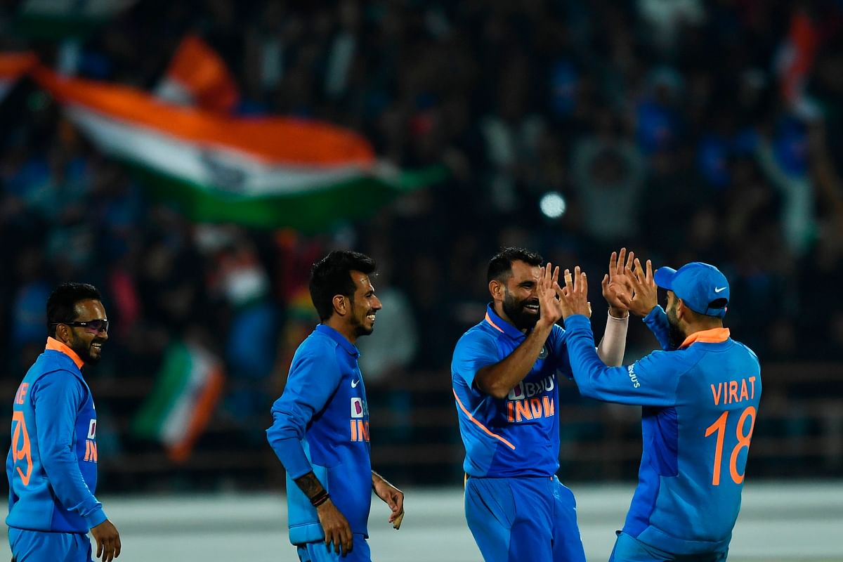 India`s Mohammed Shami (2R) celebrates with teammates after bowling out Australia`s Pat Cummins (not pictured) during the second one day international (ODI) cricket match of a three-match series between India and Australia at Saurashtra Cricket Association Stadium in Rajkot on 17 January, 2020. Photo: AFP