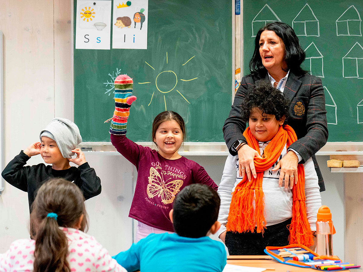Petra Revay-Schwarz, the director of Felbigergasse elementary school works with her students during a special German language class for recently arrived migrant children at Felbigergasse elementary school in Vienna, Austria on 3 December 2019. Photo: AFP