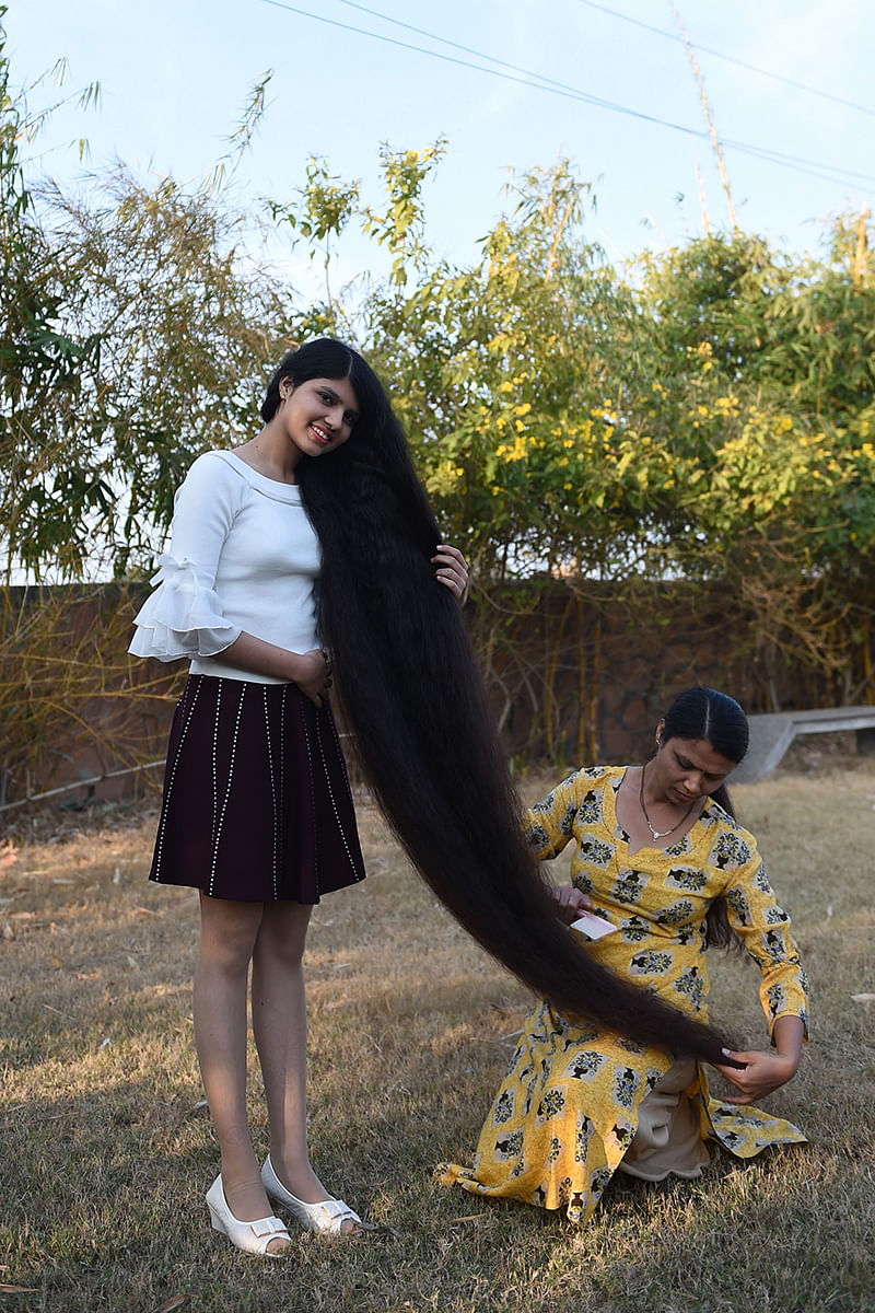 Nilanshi Patel, 17, who has been awarded the 2019 Guinness World Record for the longest hair in the teenager category, 190 cm, poses for a picture with her mother Kaminibenat at Modasa town, some 110 Kms from Ahmedabad on January 19, 2020. Patel has been awarded the 2019 Guinness World Record for the longest hair at 190 cm in the teenager category. In 2018 she bagged Guinness World Record in the same category at 170,5 cm. Photo: AFP