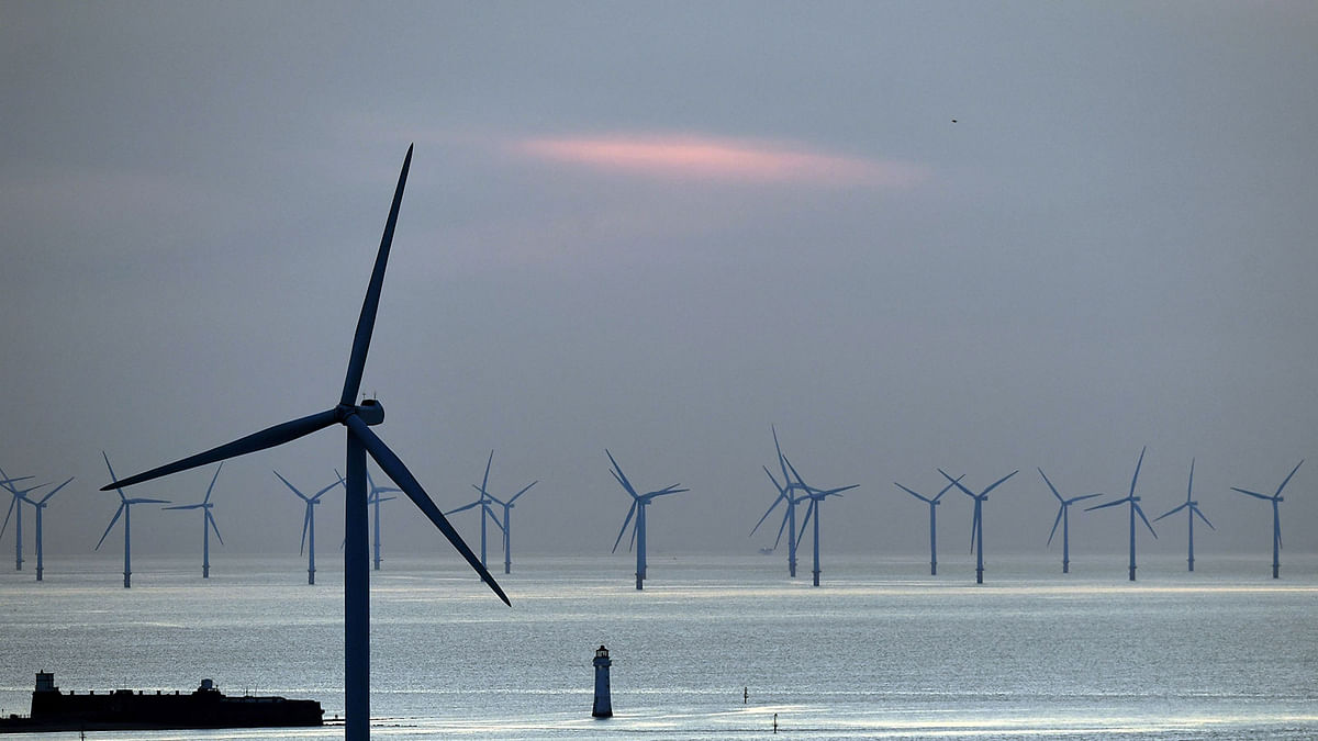 In this file photo taken on 14 May 2019 New Brighton lighthouse is pictured at sunset, in New Brighton, at the mouth of the river Mersey, in north-west England on 14 May 2019, with the Burbo Bank Offshore Wind Farm visible on the horizon. Photo: AFP