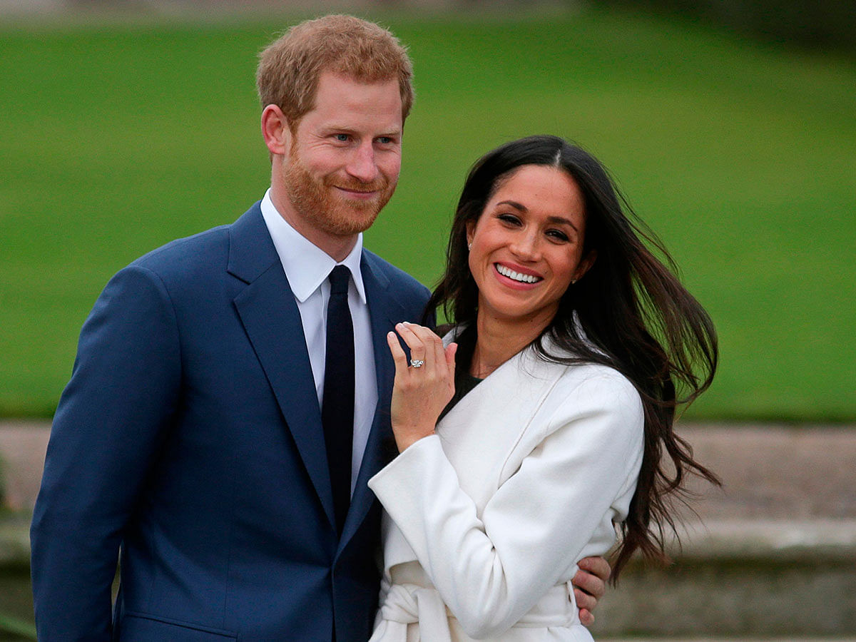 In this file photo taken on 27 November, 2017, Britain`s prince Harry stands with his fiancee US actress Meghan Markle as she shows off her engagement ring whilst they pose for a photograph in the Sunken Garden at Kensington Palace in west London, following the announcement of their engagement. Photo: AFP