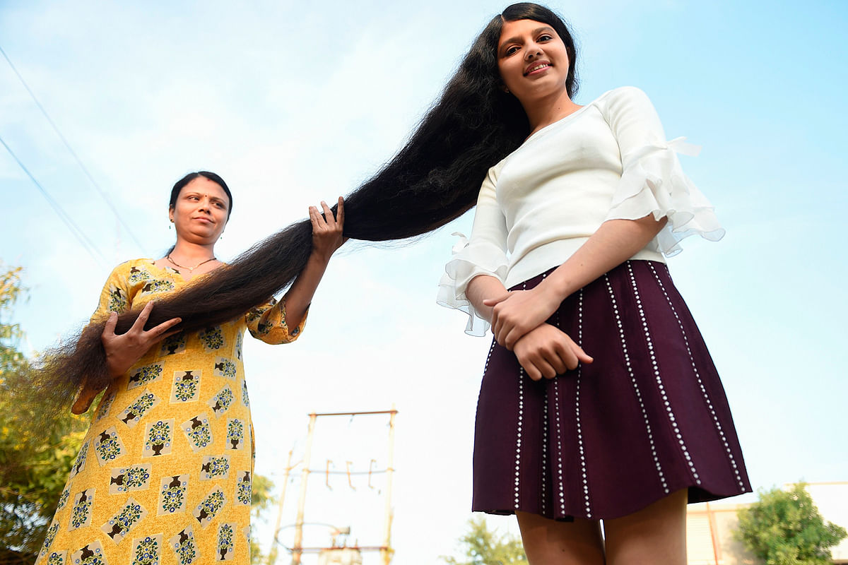 Nilanshi Patel, 17, who has been awarded the 2019 Guinness World Record for the longest hair in the teenager category, 190 cm, poses for a picture with her mother Kaminibenat at Modasa town, some 110 Kms from Ahmedabad on 19 January 2020. Photo: AFP