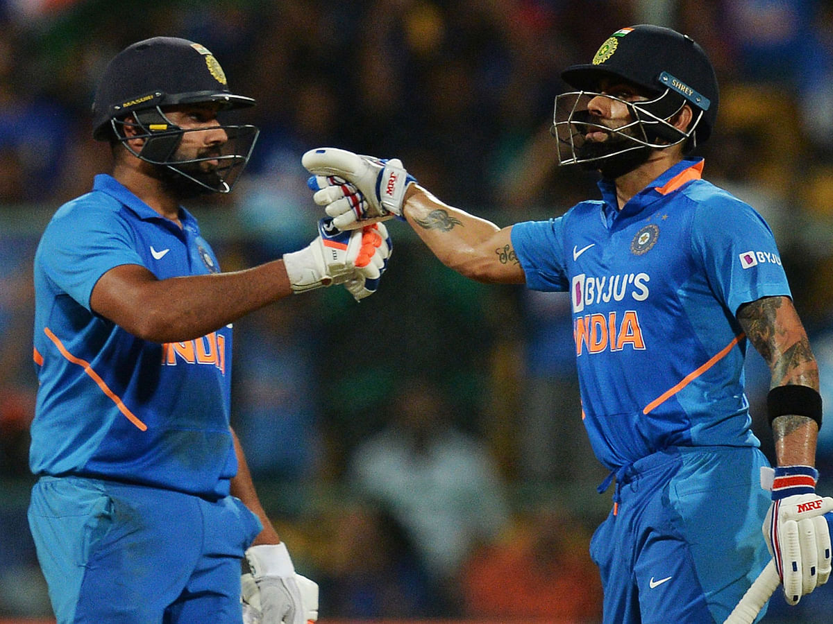 India`s Virat Kohli (R) and Rohit Sharma greet each other during the third and last one day international (ODI) cricket match of a three-match series between India and Australia at the M. Chinnaswamy Stadium in Bangalore on 19 January 2020. Photo: AFP