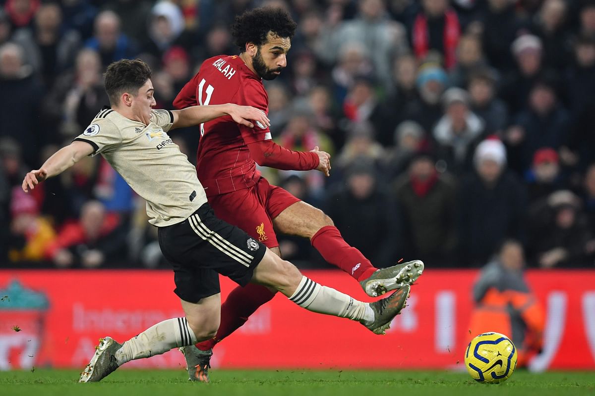 Liverpool`s Egyptian midfielder Mohamed Salah (R) shoots to score their second goal as Manchester United`s Welsh midfielder Daniel James (L) slides to attempt a block during the English Premier League football match between Liverpool and Manchester United at Anfield stadium in Liverpool, north west England on January 19, 2020. AFP