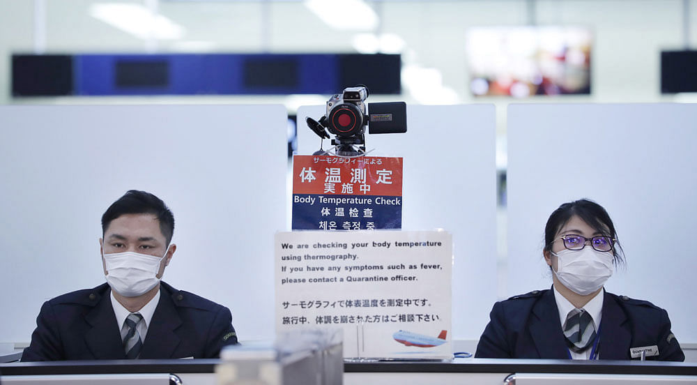 In this picture taken on 16 January 2020, officers work at a health screening station as they observe passengers arriving on a flight from Wuhan, China, where a SARS-like virus was discovered and has since spread, at Narita airport. Photo: AFP
