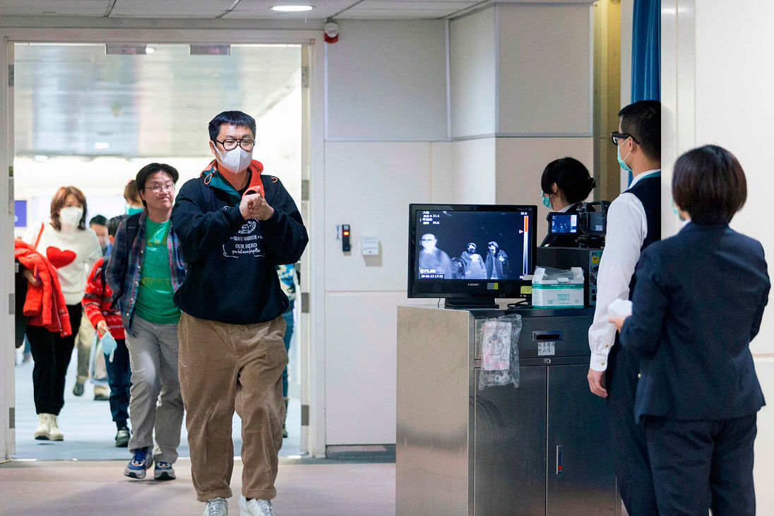This picture taken on 13 January 2020 shows Taiwan`s Center for Disease Control (CDC) personnel (R) using thermal scanners to screen passengers arriving on a flight from China`s Wuhan province, where a SARS-like virus was discovered and has since spread, at the Taoyuan International Airport. Photo: AFP
