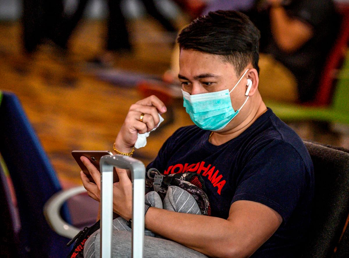 A passenger wears a face mask while waiting to board his flight at Yangon International Airport on 21 January 2020. Photo: AFP  China warns SARS-like virus may spread as death toll hits 9