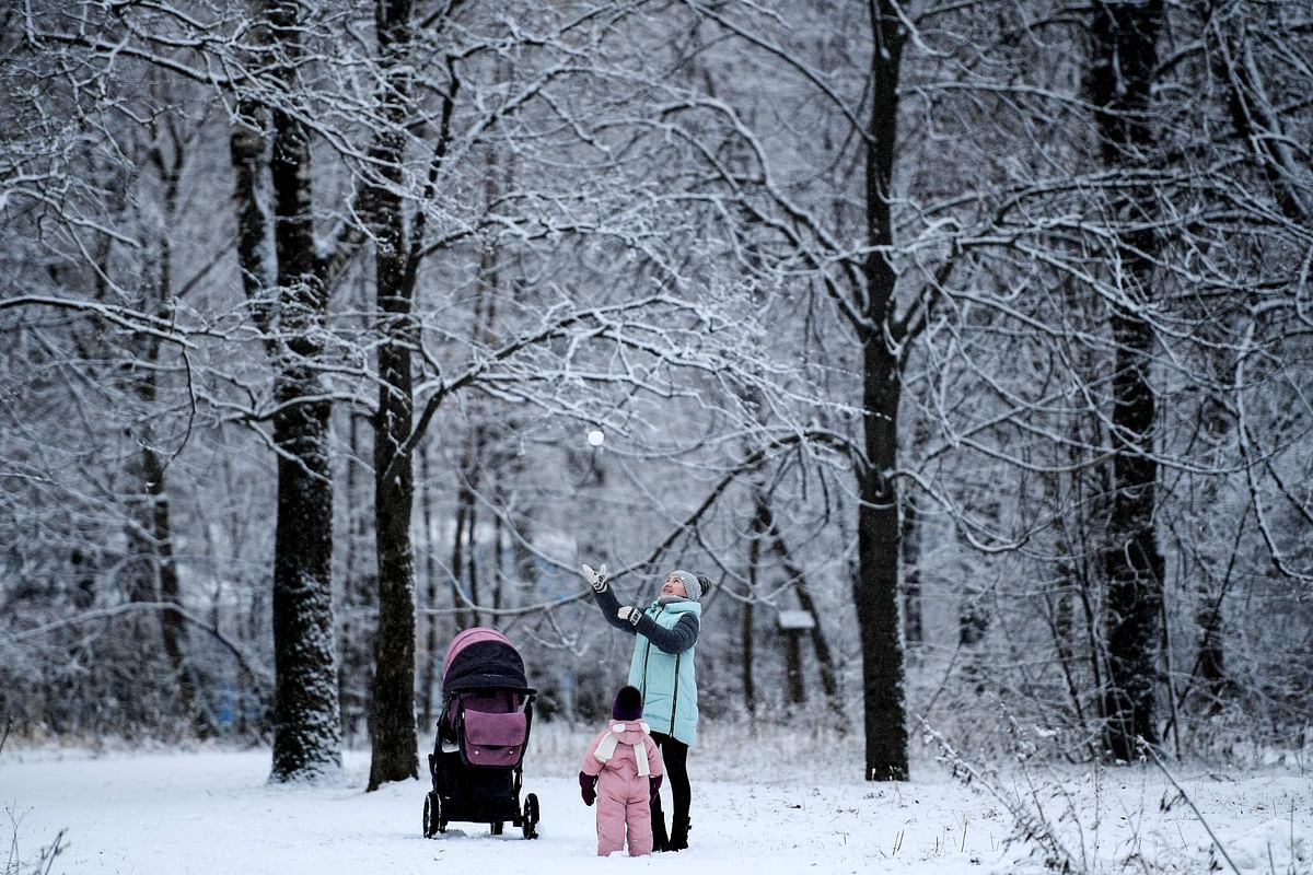 A woman plays with a child in Moscow`s Tushino park after a snowfall on 22 January 2020. Photo: AFP