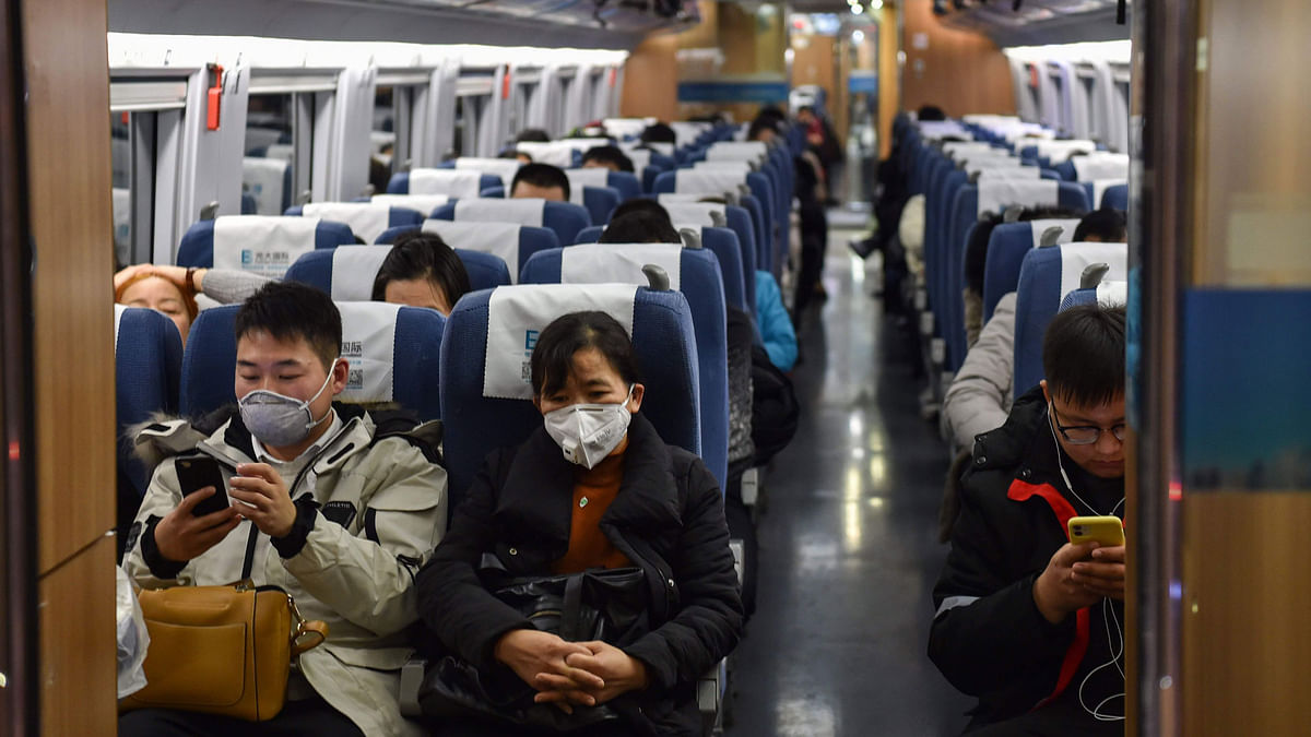People wearing masks sit in a train for the direction of Wuhan City at Hongqioa train station as they head home for the Lunar New Year in Shanghai on 23 January 2020 China placed the city at the centre of a virus outbreak under effective quarantine, suspending outward flights and trains in a drastic step to contain a contagious disease that has killed 17, stricken hundreds and reached other countries. Photo: AFP