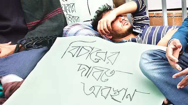 A student of DU stages sit-in at the base of Raju Sculpture demanding justice over torture by BCL men on Tuesday night. Photo: Prothom Alo