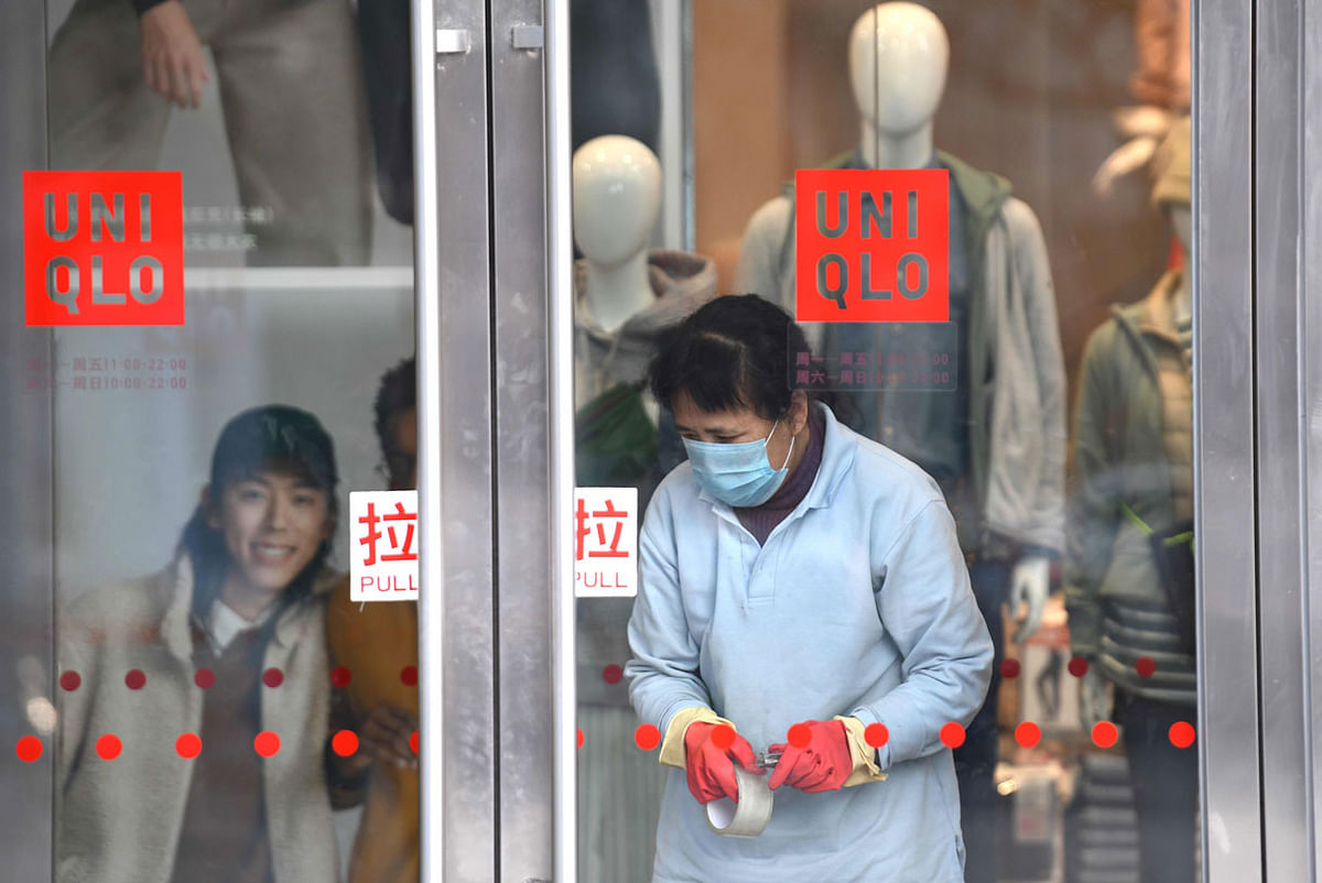 A worker wearing a protective mask is seen inside a shop at a mall in Beijing on 24 January. Photo: AFP