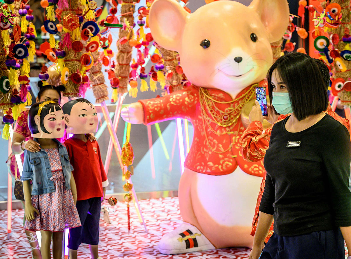 A woman with a face mask walks in a shop decorated for the Chinese Lunar New Year in Bangkok on January 24, 2020, after four people were detected with the Coronavirus in Thailand. Photo: AFP