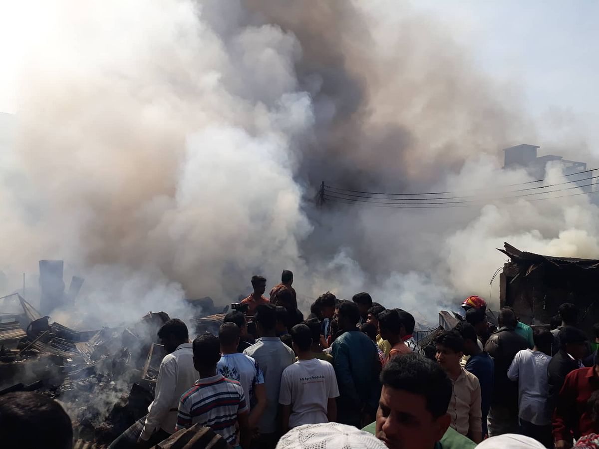People watch as fire guts slum in Mirpur’s Chalantika on 24 January 2020. Photo: Prothom Alo