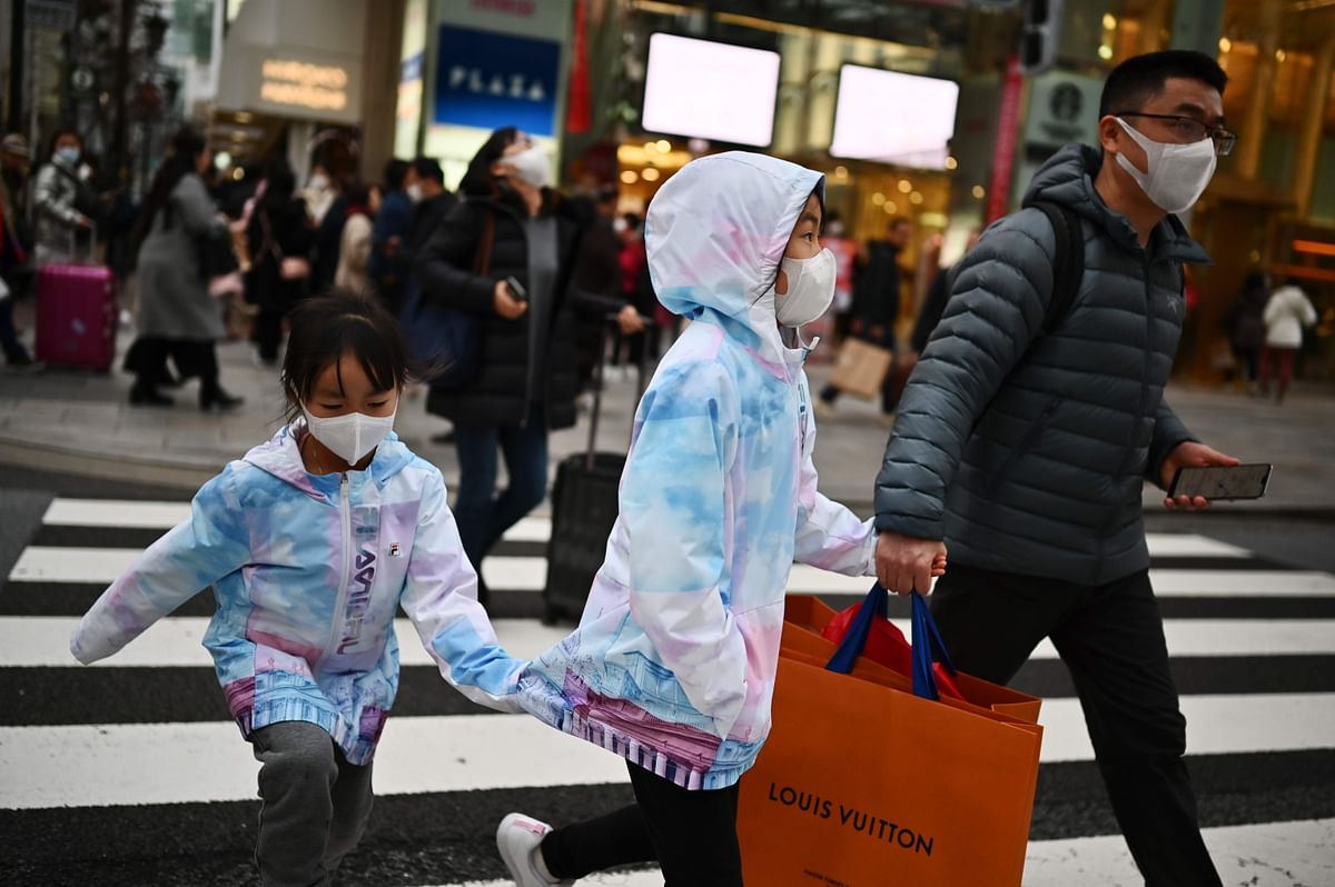 Pedestrians wearing protective masks to help stop the spread of a deadly virus which began in the Chinese city of Wuhan, walk on a street in Tokyo`s Ginza area on 25 January 2020. Photo: AFP