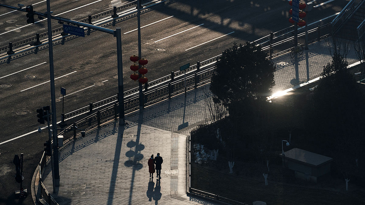 People wear masks as they walk down an empty main street in central Beijing, on 25 January 2020. Photo: Reuters