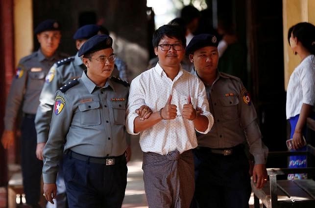 Detained Reuters journalist Wa Lone escorted by police, arrives for a court hearing in Yangon. Photo: Reuters