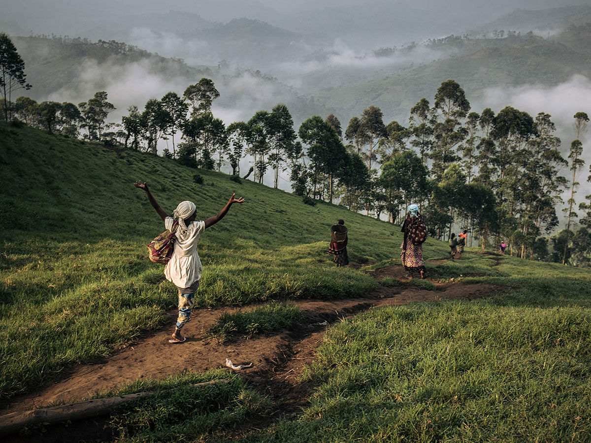 A group of women descend the hills of Masisi at dawn on 15 January 2020. Since late 2019, a cholera epidemic has been affecting internally displaced people (IDPs) in the Masisi territory, who are fleeing fighting between armed groups. Photo: AFP