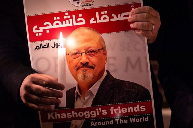 A demonstrator holds a poster picturing Saudi journalist Jamal Khashoggi and a lightened candle during a gathering outside the Saudi Arabia consulate in Istanbul, on 25 October 2018. Photo: AFP