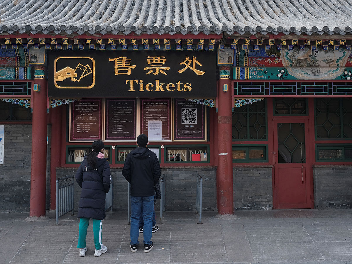 People stand in front of the closed tickets office to the Juyongguan section of the Great Wall, where a notice is seen saying that the place is closed to visitors for the safety concern following the outbreak of a new coronavirus, near Beijing, China on 25 January 2020. Photo: Reuters