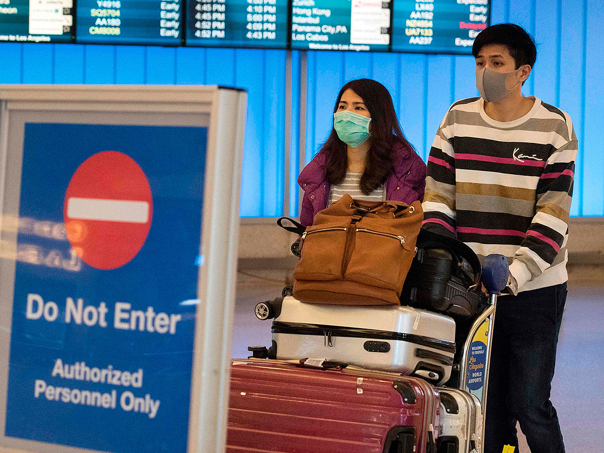 In this file photo taken on 22 January, 2020 passengers wear protective masks to protect against the spread of the Coronavirus as they arrive at the Los Angeles International Airport, California. Photo: AFP
