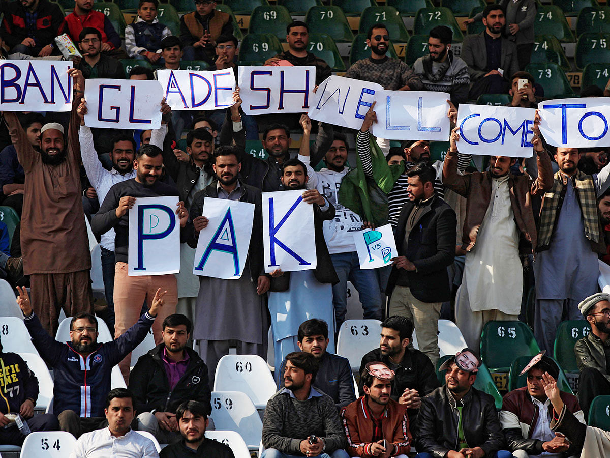 People hold signs during a T20 series match between Bangladesh and Pakistan cricket teams at Gaddafi Stadium Lahore, Pakistan on 24 January 2020. Photo: Reuters