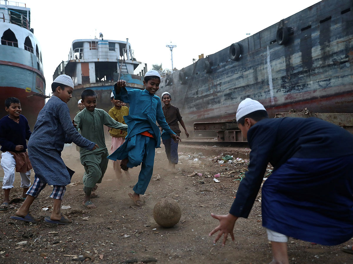 Children play football in a dockyard in Dhaka, Bangladesh, 21 January 2020. Photo: Reuters