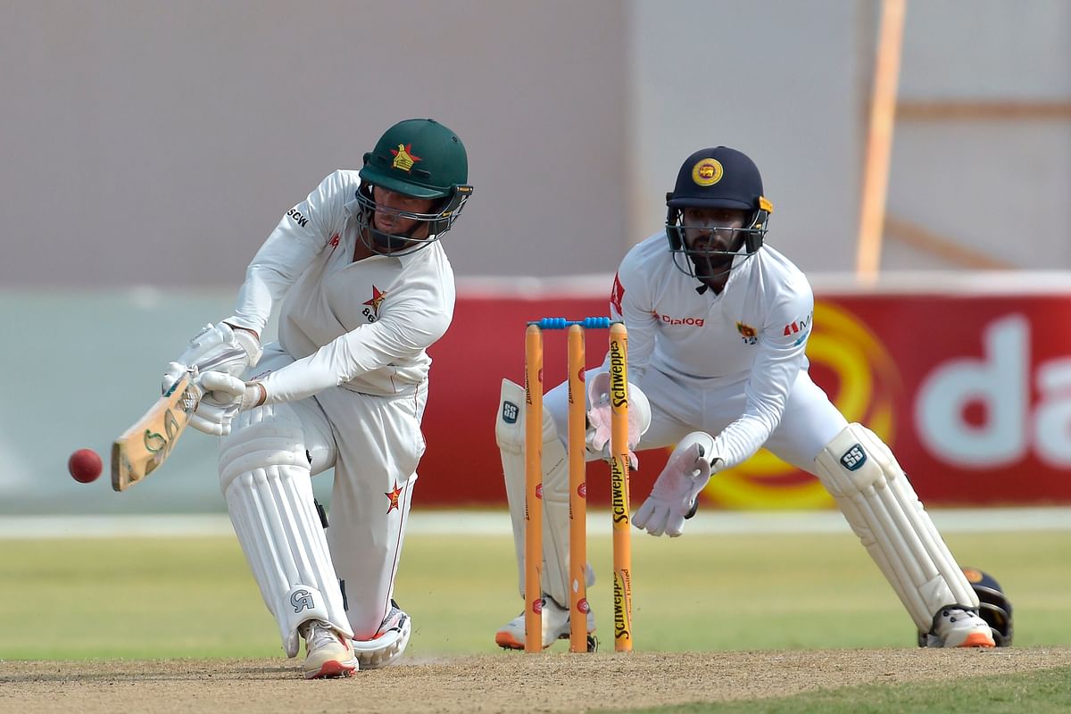 Zimbabwe`s captain Sean Williams (L) plays a shot as Sri Lanka`s Niroshan Dickwella (R) looks on during the first day of the second Test cricket match between Zimbabwe and Sri Lanka at the Harare Sports Club in Harare on 27 January 2020. Photo: AFP