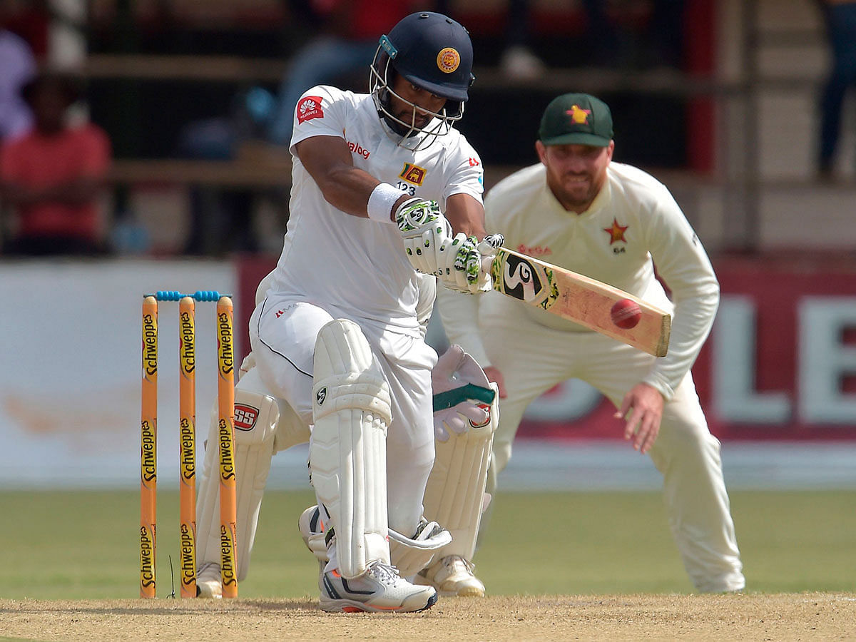 Sri Lanka`s captain Dimuth Karunaratne (L) plays a shot as Zimbabwe`s Brendan Taylor (R) looks on during the second day of the second Test cricket match between Zimbabwe and Sri Lanka at the Harare Sports Club in Harare on 28 January 2020. Photo: AFP