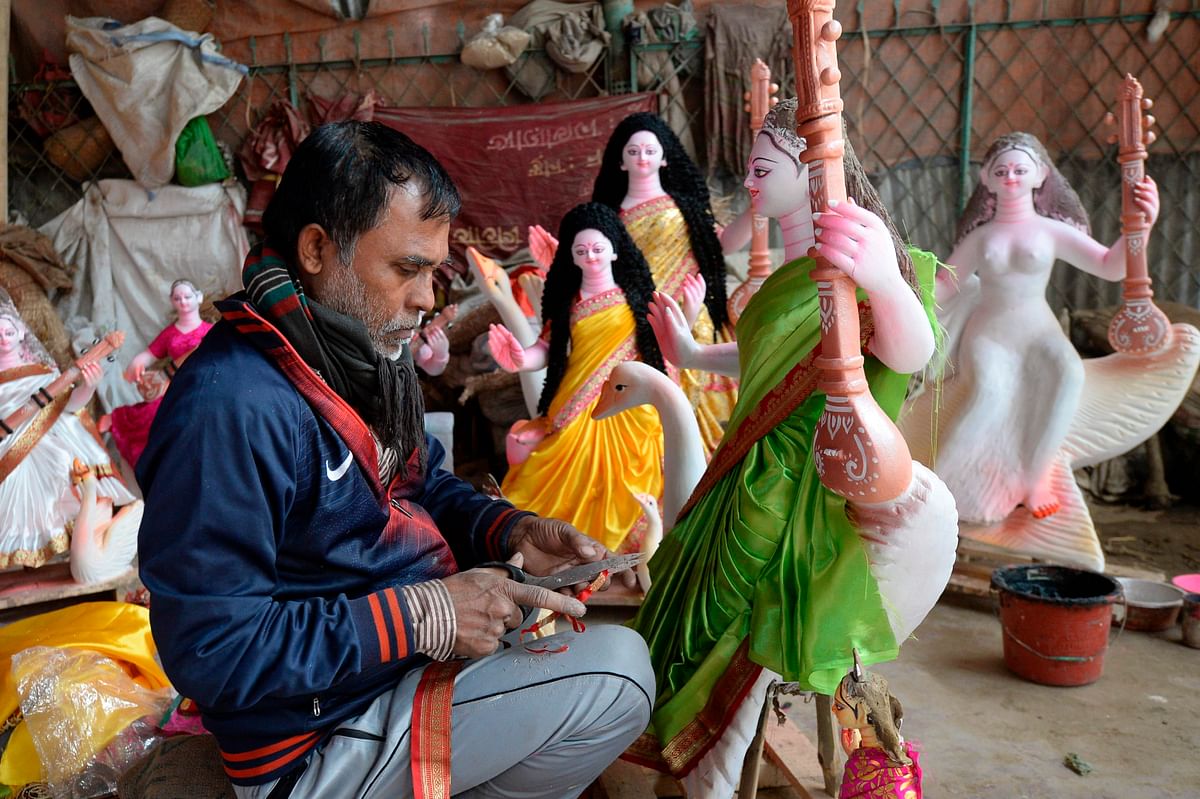 An artist gives final touches to an idol of Goddess Saraswati ahead of the upcoming Saraswati Puja in Dhaka on 28 January 2020. Photo: AFP Tag: Saraswati, Puja, Festival, dhaka