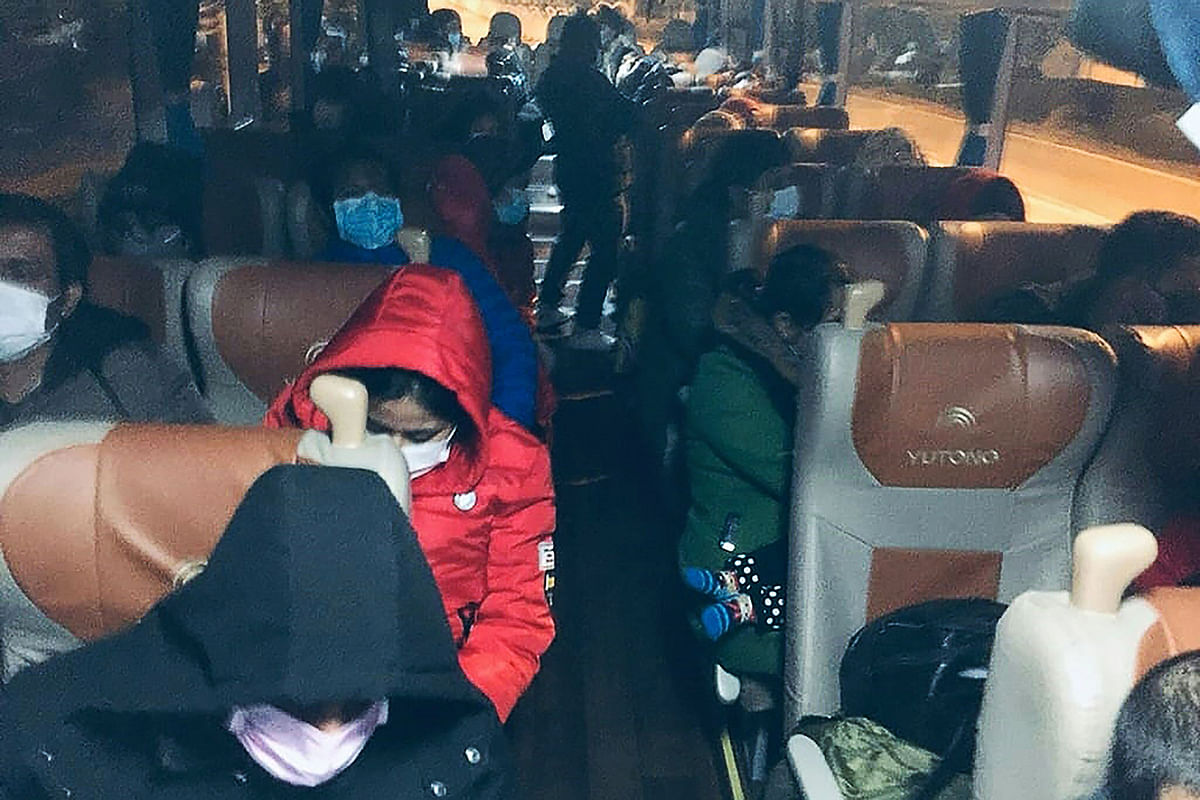 Bangladeshi citizens, mostly students, wearing facemasks sit on a bus as they are chartered to Wuhan airport on 31 January, 2020, as the Bangladeshi government prepares to evacuate them following a SARS-like virus outbreak in the city of Wuhan. Photo: AFP