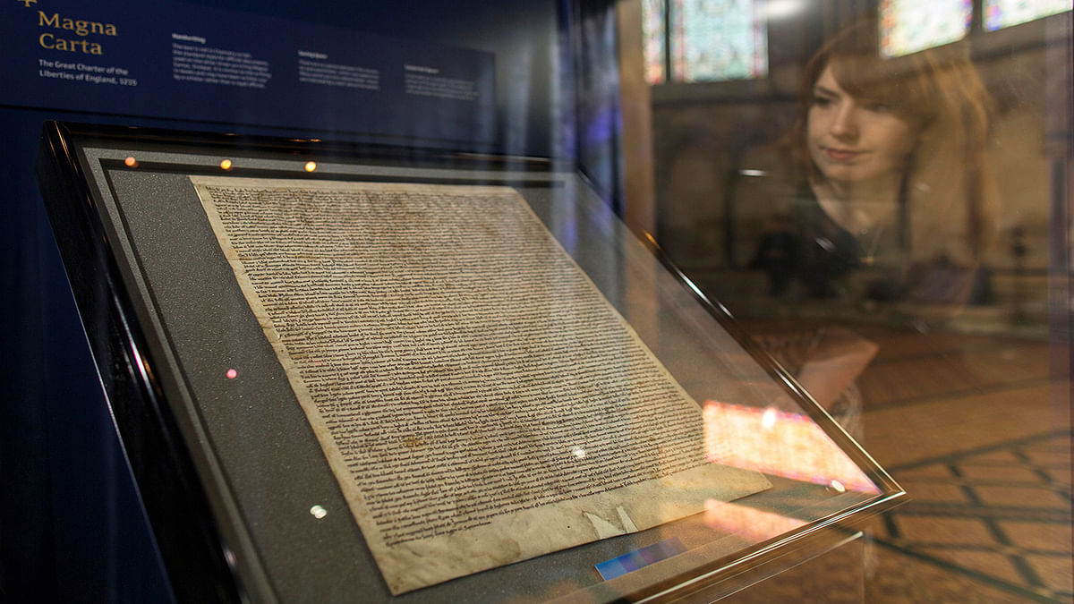 Meg Bullock of Salisbury Cathedral poses for photographers as she looks at the Salisbury Magna Carta, one of the original four remaining Magna Carta documents, as part of a new interactive exhibition in Chapter House at Salisbury Cathedral in Salisbury, southern England on 27 February 2015. Reuters File Photo