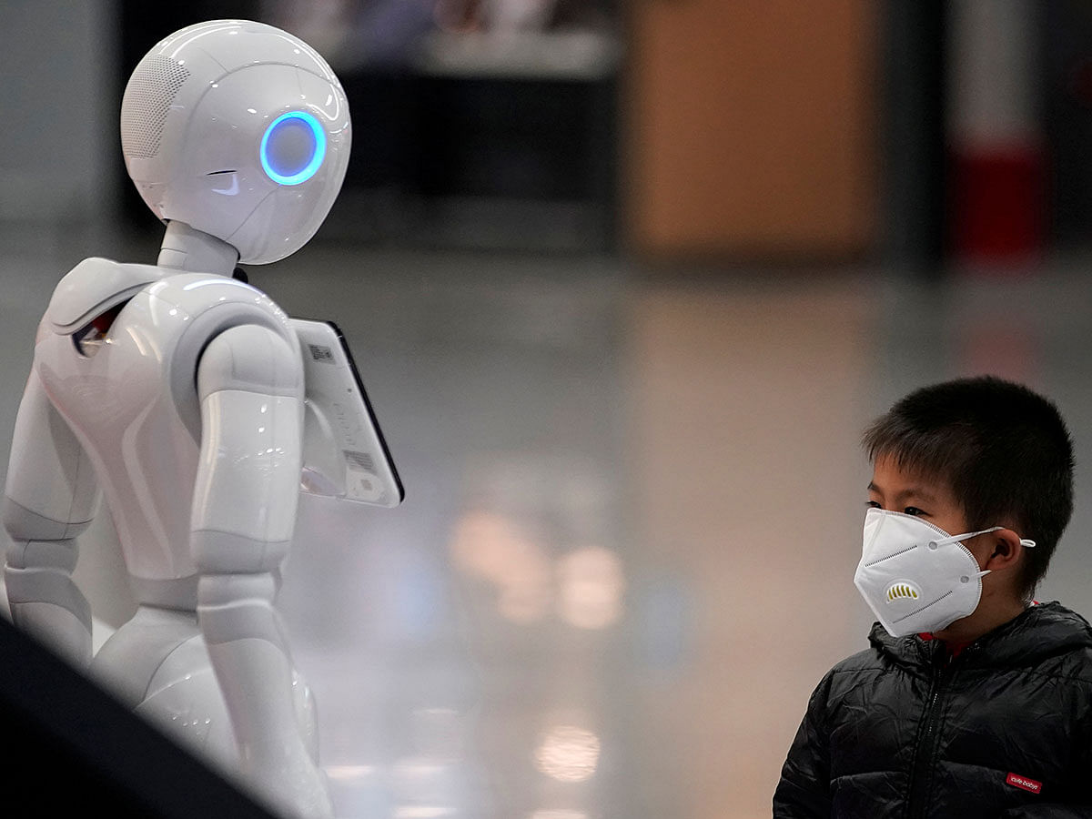 Boy wears a mask watching a robot at the Pudong International Airport in Shanghai. Photo: AFP