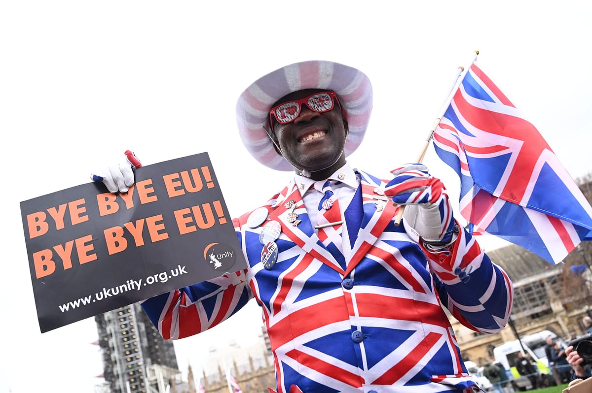Joseph Afrane, bedecked in Union flag colours, holds up a sign saying `Bye bye EU` on Parliament Square opposite the Houses of Parliament in London on 31 January 2020 on the day that the UK formally leaves the European Union. Photo: AFP
