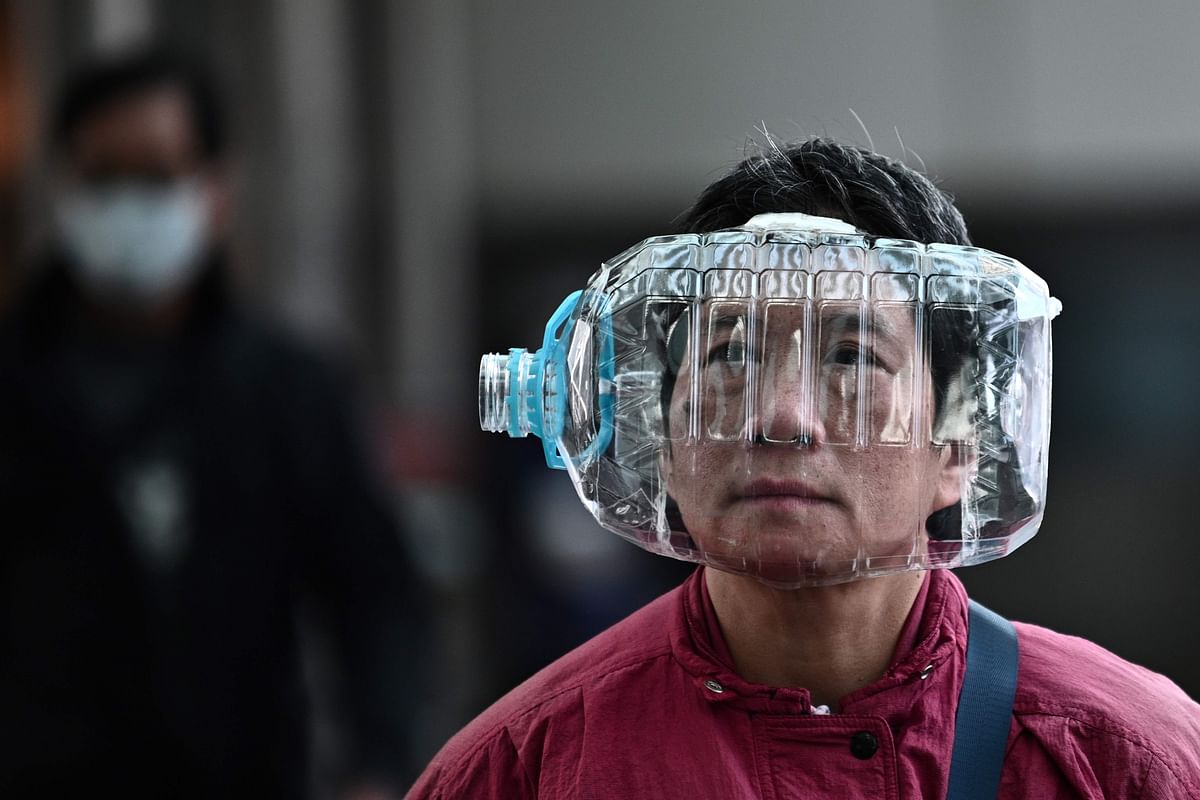 A woman wears a plastic water bottle with a cutout to cover her face, as she walks on a footbridge in Hong Kong on 31 January 2020, as a preventative measure following a virus outbreak which began in the Chinese city of Wuhan. Photo: AFP