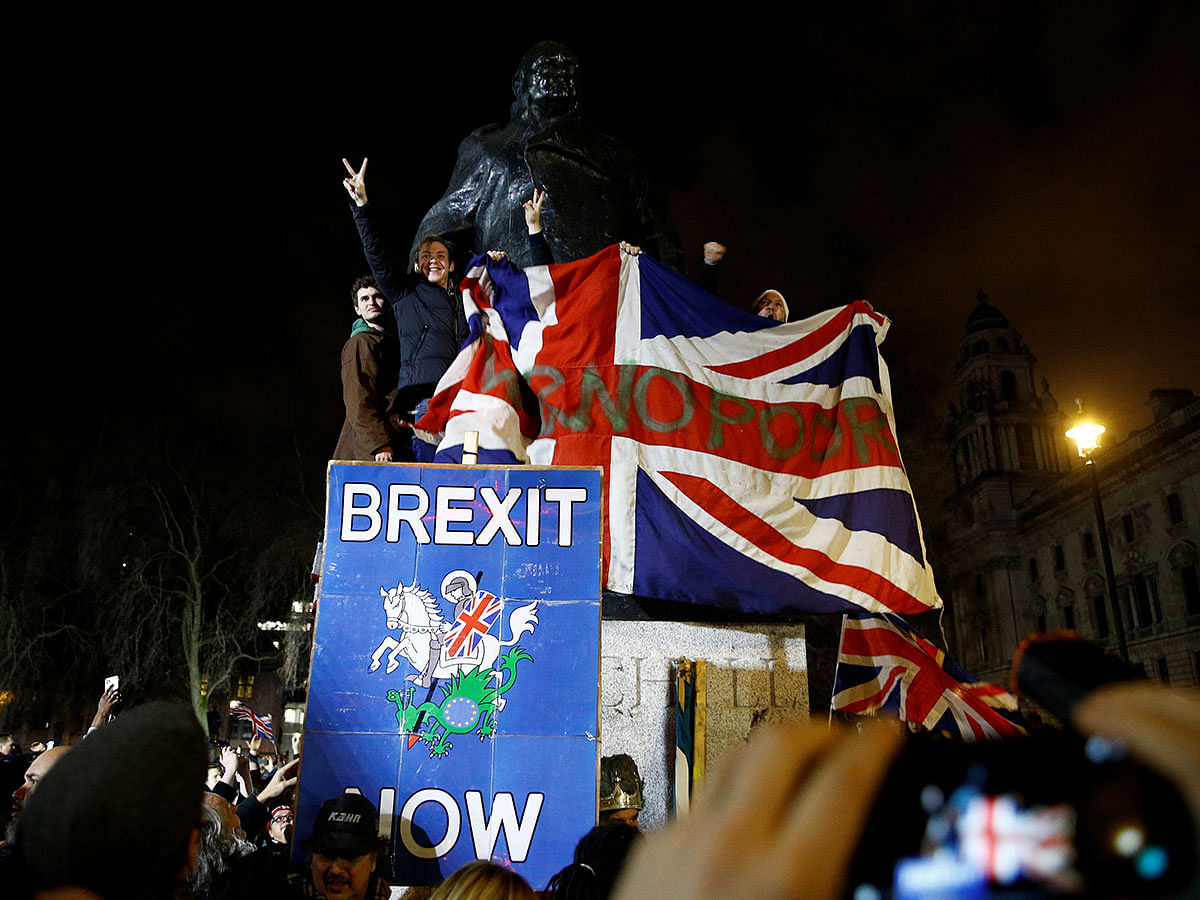 People stand at the statue of Winston Churchill as they celebrate Britain leaving the EU on Brexit day in London, Britain on 31 January. Photo: Reuters