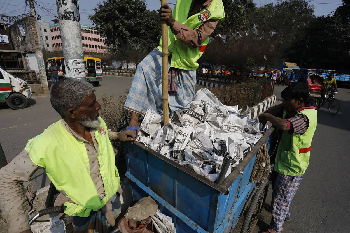 People collect posters of city corporation polls on the following day of DNCC, DSCC elections at Tejgaon, Dhaka on 2 February 2020. Photo: Dipu Malakar