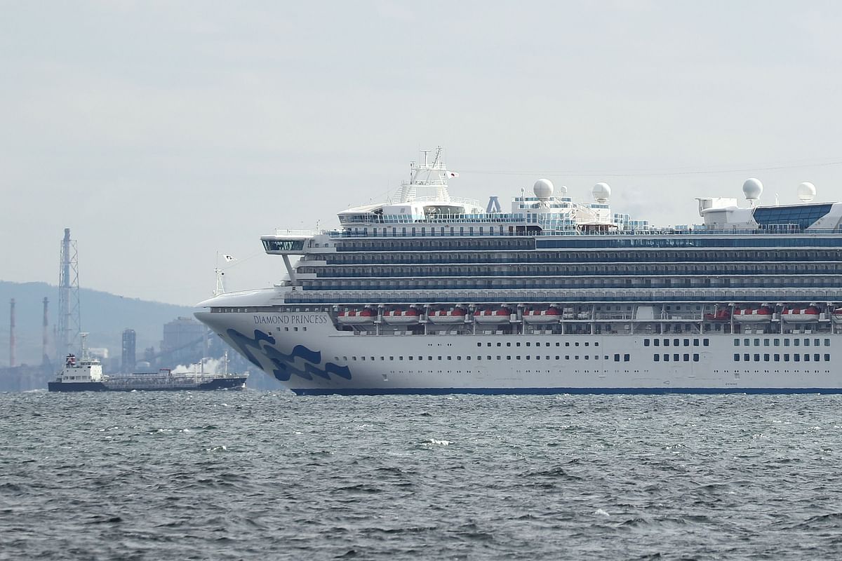The Diamond Princess cruise ship (R) with over 3,000 people sits anchored in quarantine off the port of Yokohama on 4 February 2020, a day after it arrived with passengers feeling ill. Japan has quarantined the cruise ship carrying 3,711 people and was testing those onboard for the new coronavirus on 4 February after a passenger who departed in Hong Kong tested positive for the virus. Photo: AFP