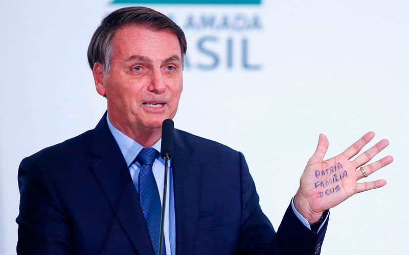Brazil’s president Jair Bolsonaro shows written on the palm of his hand “ Homeland, Family, God “ during a ceremony to mark his 400 days in office at the Planalto palace, in Brasilia, Brazil, on 5 February. Photo: AFP