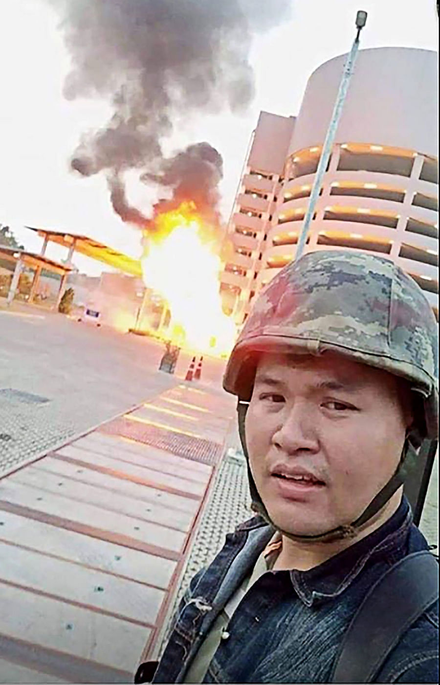 This screenshot made on February 8, 2020 from the Facebook livestream video of Thai soldier Jakrapanth Thomma shows him standing in front of a building on fire during an attack in the northeastern city of Nakhon Ratchasima on 8 February. Photo: AFP