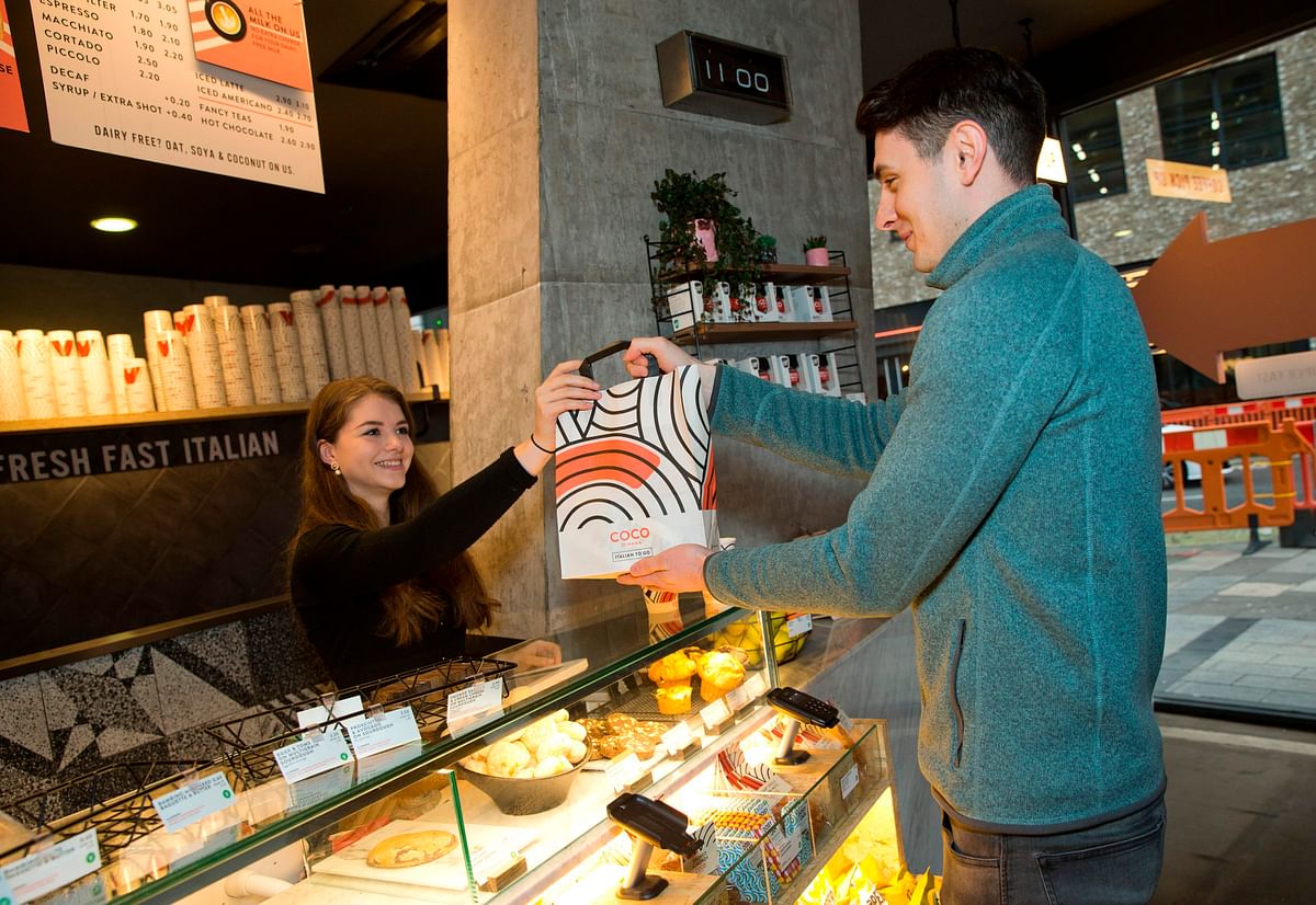 A Karma app user collects his food, ordered through the food-sharing app, from a Coco Di Mama food outlet -- a store partnered with the Karma app -- in this posed photograph taken in London, on 22 January 2020. Photo: AFP