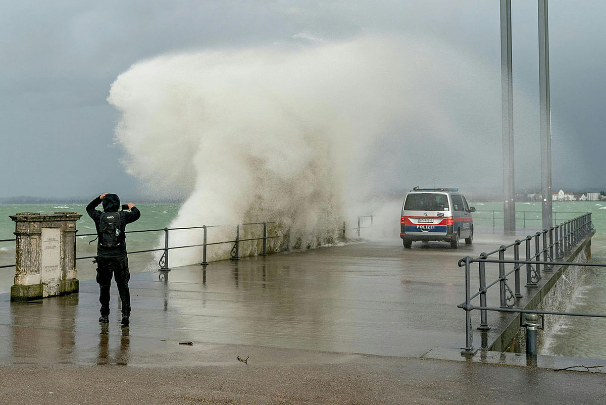 A man photographs while water spills over a quay in the Eastern end of Lake Constance (Bodensee), as the storm Ciara reaches Austria, in Bregenz, Austria, on 10 February 2020. Photo: AFP