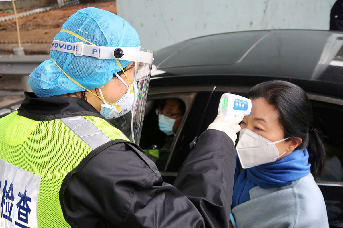 A security officer in a protective mask checks the temperature of a passenger following the outbreak of a new coronavirus, at an expressway toll station on the eve of the Chinese Lunar New Year celebrations, in Xianning, a city bordering Wuhan to the north, Hubei province, China on 24 January. Photo: Reuters