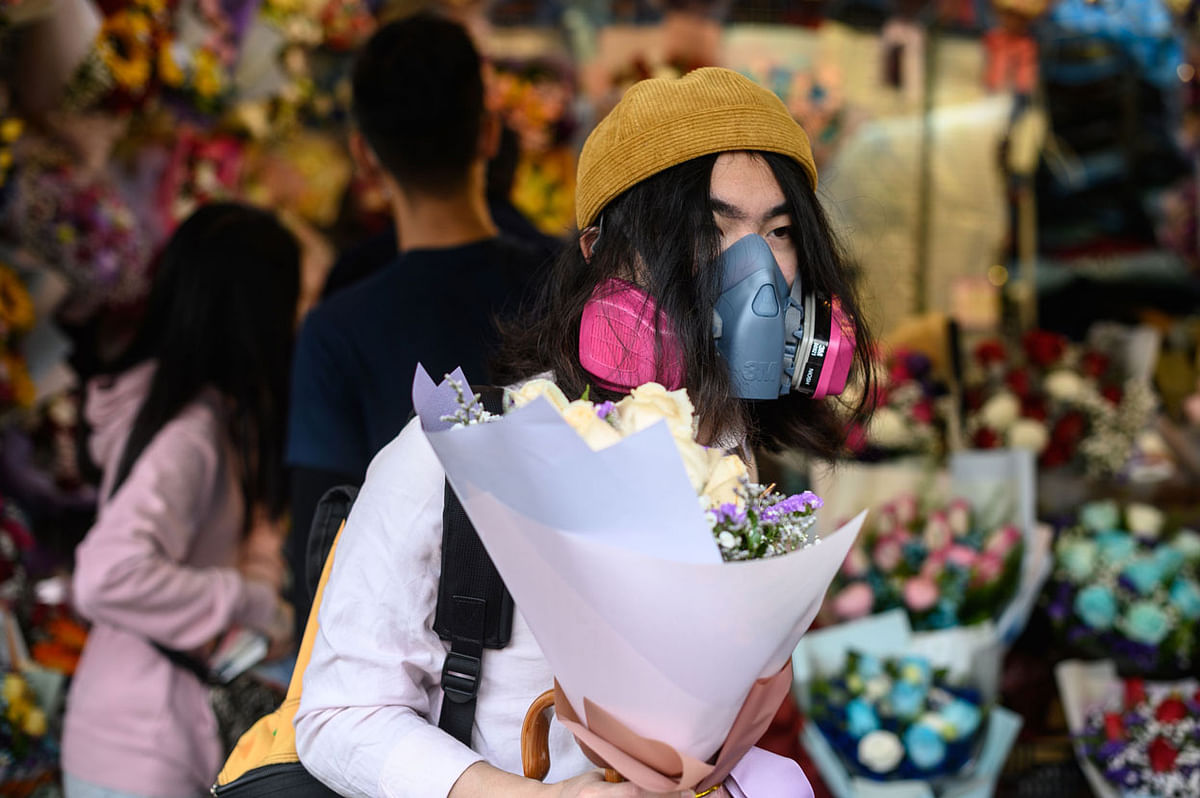 A man wearing a protective face mask as a preventative measure against the COVID-19 coronavirus, buys flowers to mark Valentine`s Day in Hong Kong on 14 February 2020. Photo: AFP