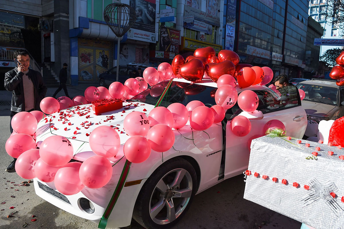 A vendor decorates a car with balloons on Valentine`s Day in Kabul on 14 February 2020. Photo: AFP
